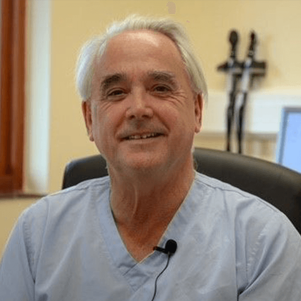 Dr Peter Holloway sits, smiling, in an office.