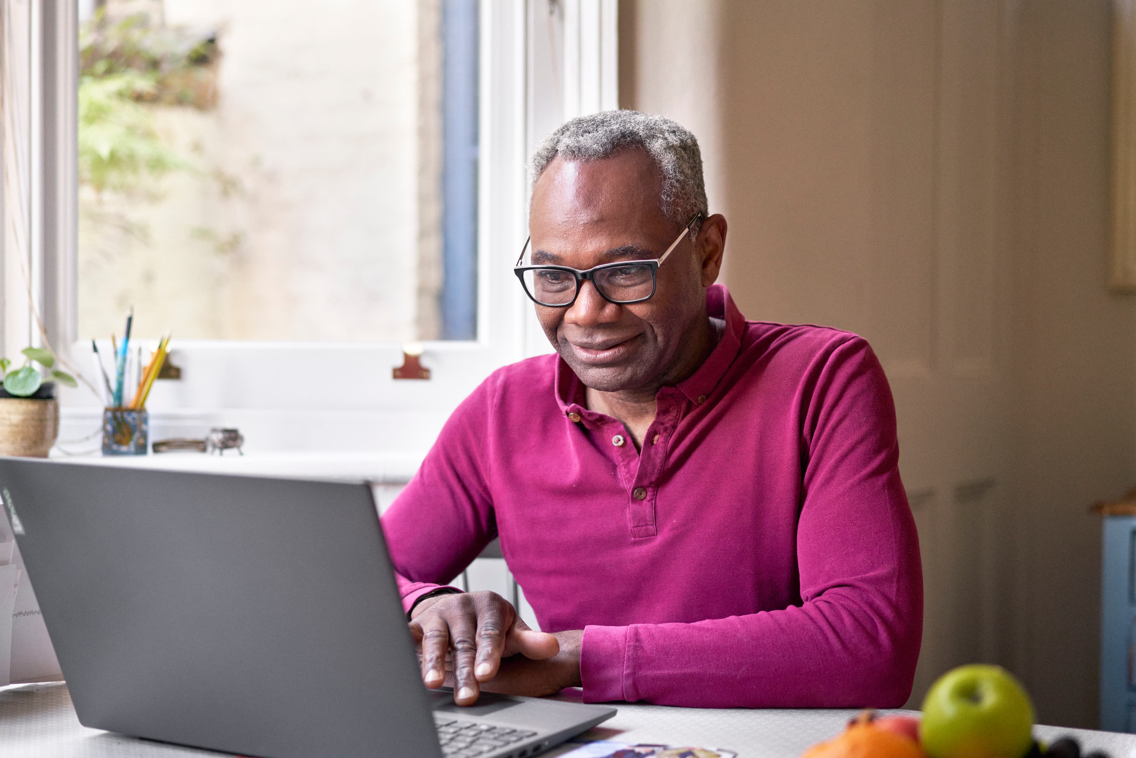 A photo of a man looking at his laptop.