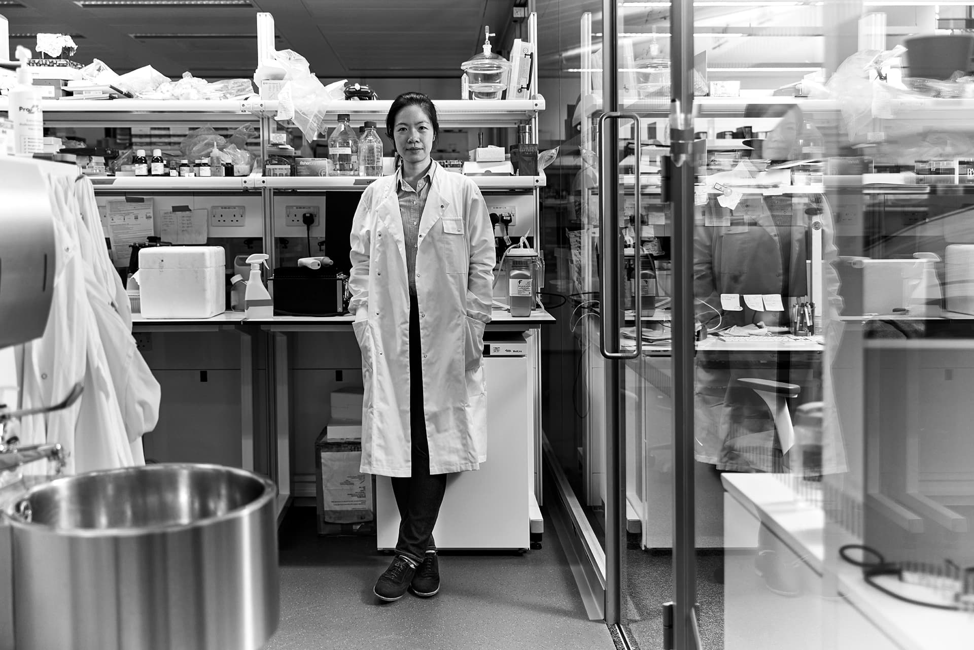 Dr Leanne Li wearing her lab coat, standing in a laboratory.