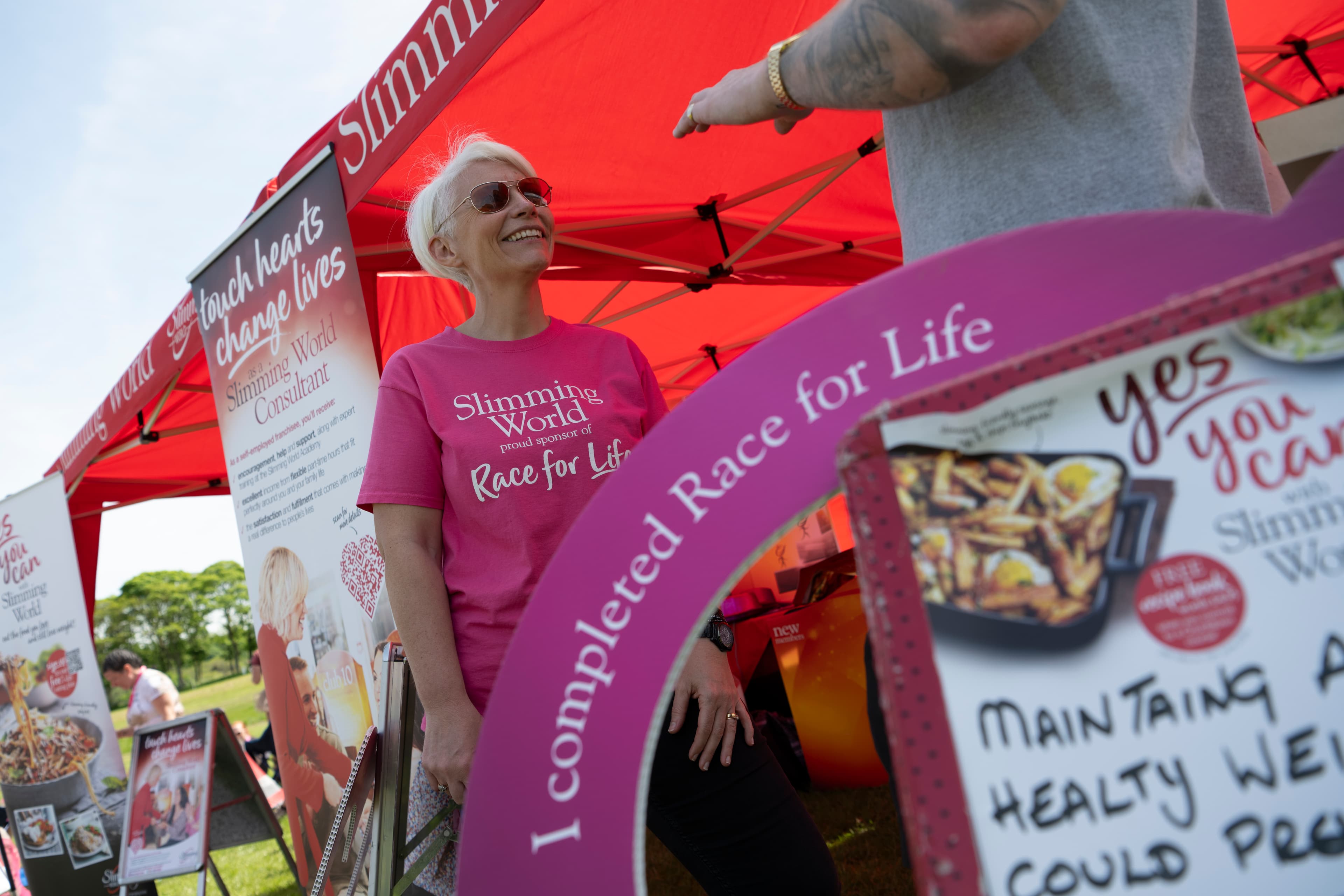 A woman at a Slimming World stand at a Race for Life event.