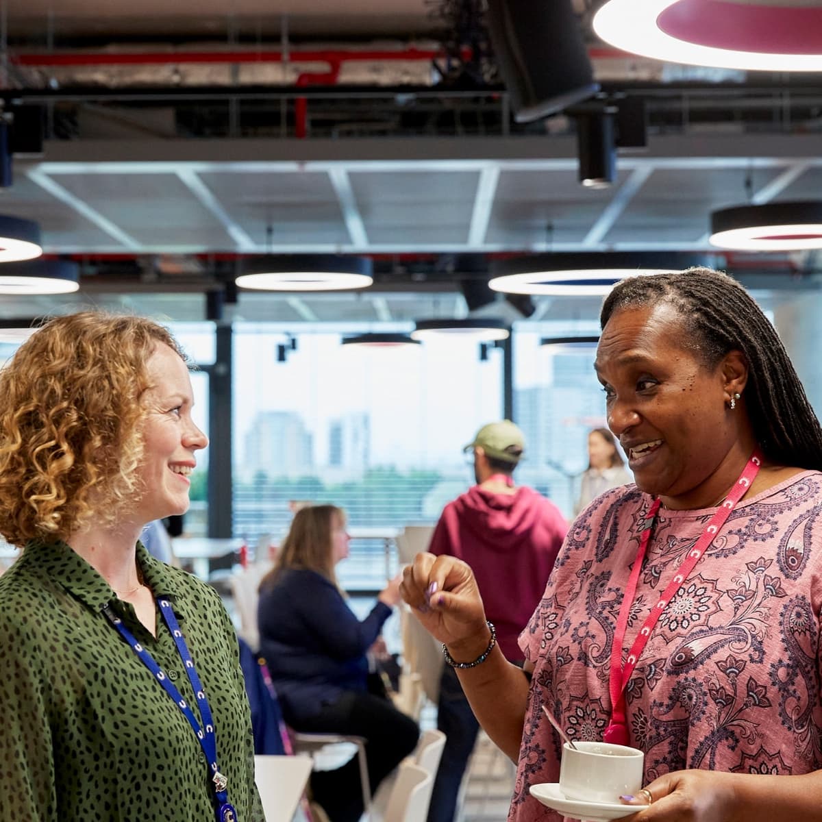 Two people standing and facing each other, having a friendly discussion.