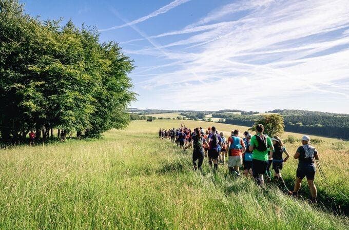 group of people on a trek in a green field.