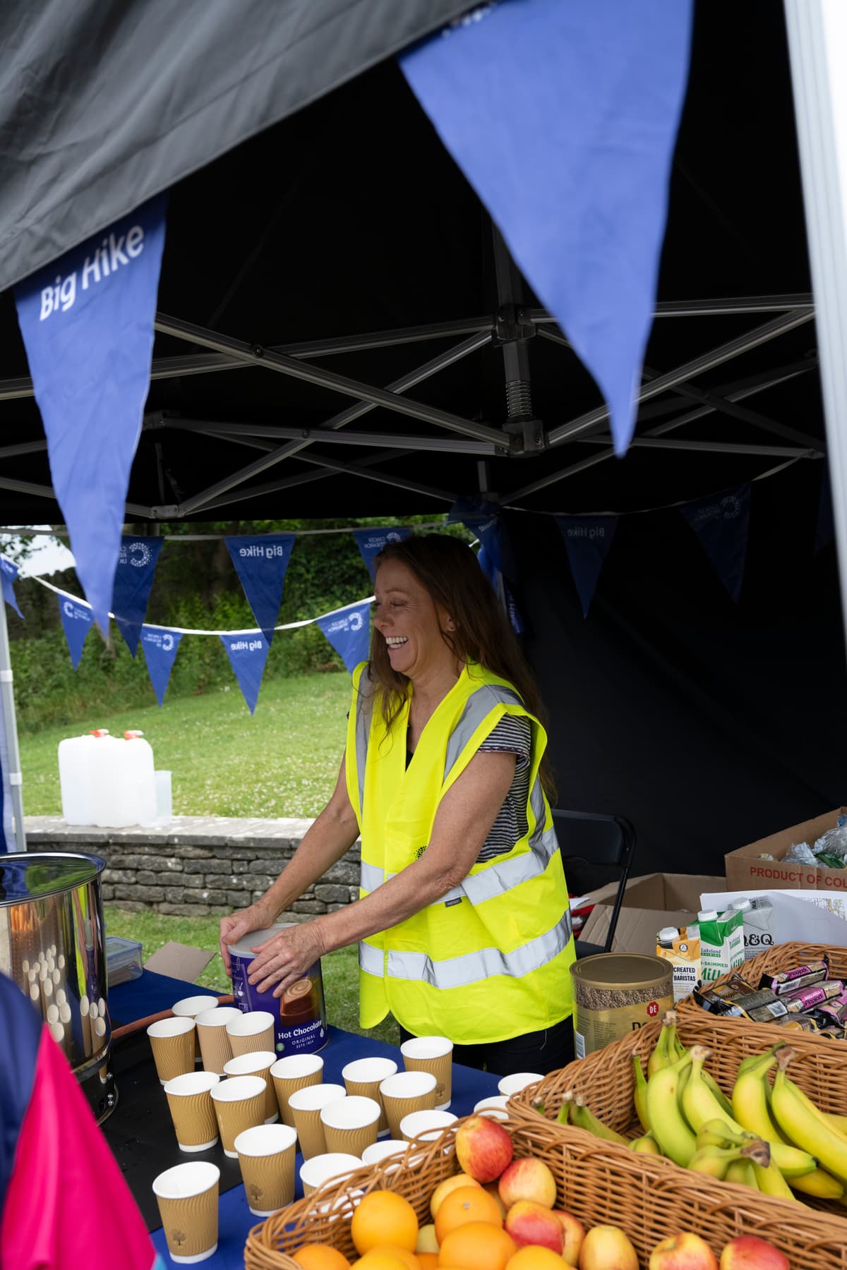 A Cancer Research UK volunteer handing out hot drinks to hikers.