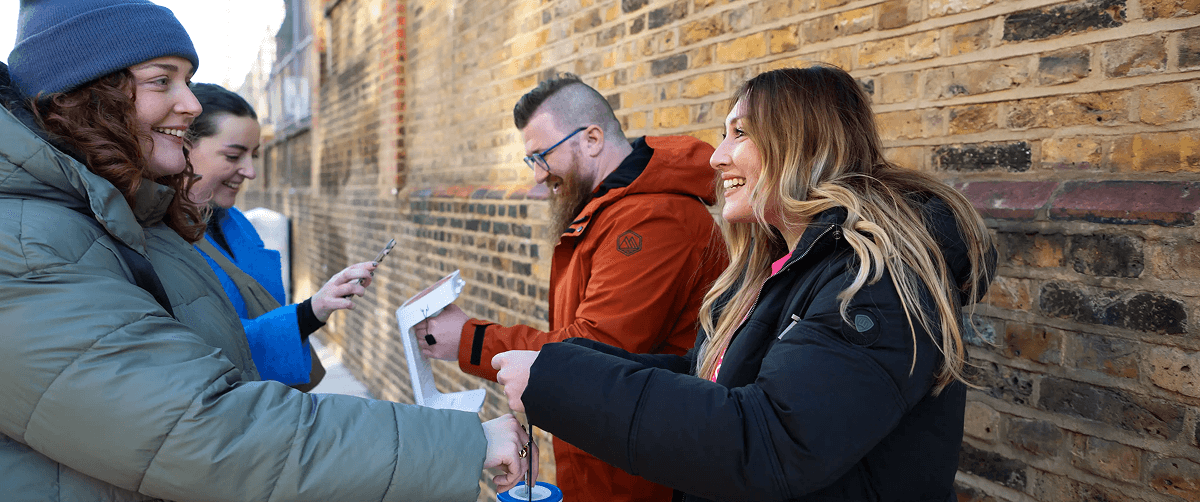 A photo of two Cancer Research UK volunteers fundraising for the charity.