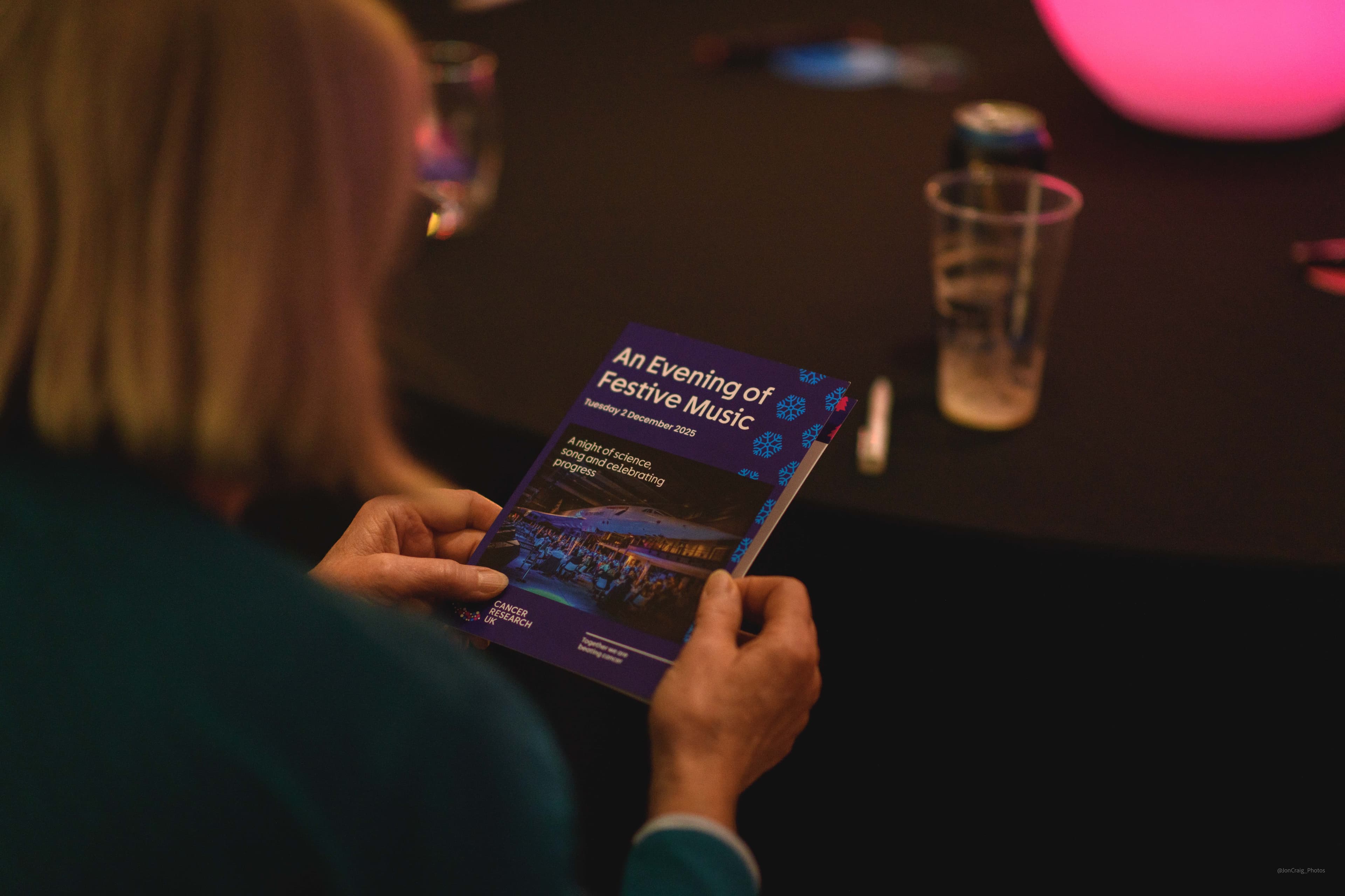 Hands holding a programme for a Legacy Festive of Music event.