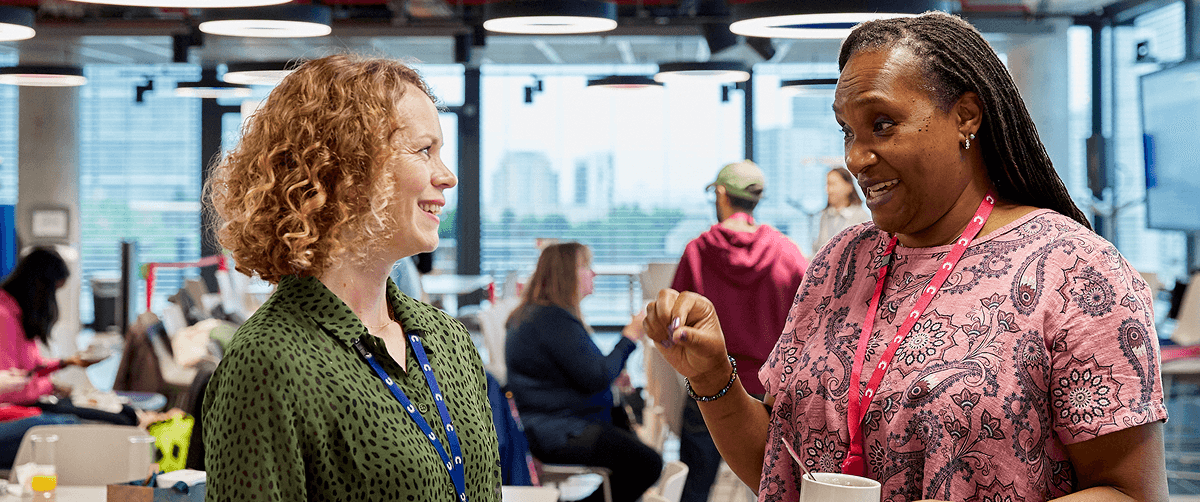 Two people standing and facing each other, having a friendly discussion.