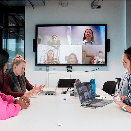 A photo of three people sat around a screen on a video call with several people, from the Cancer Insights Panels' event.