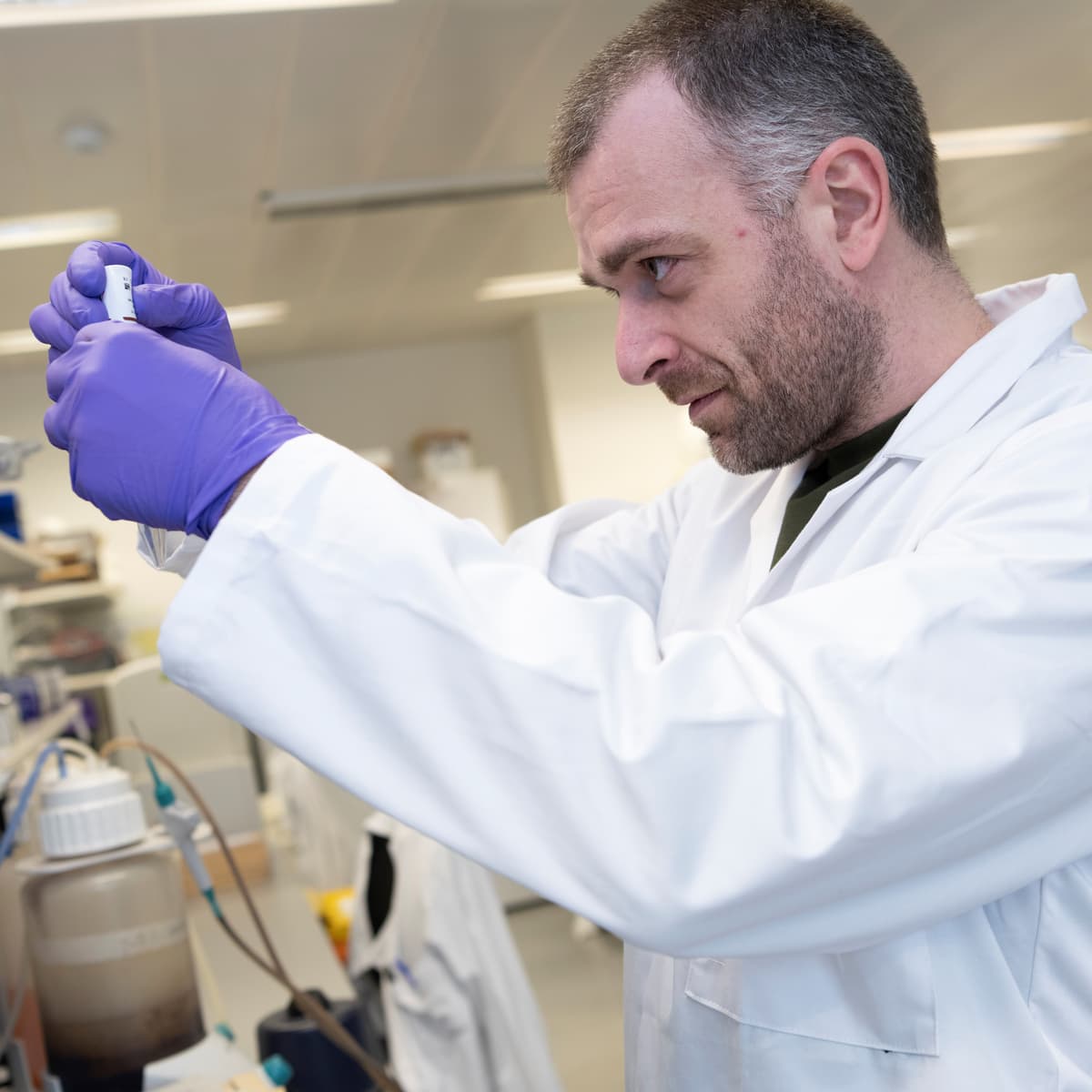A researcher pipetting in a lab.
