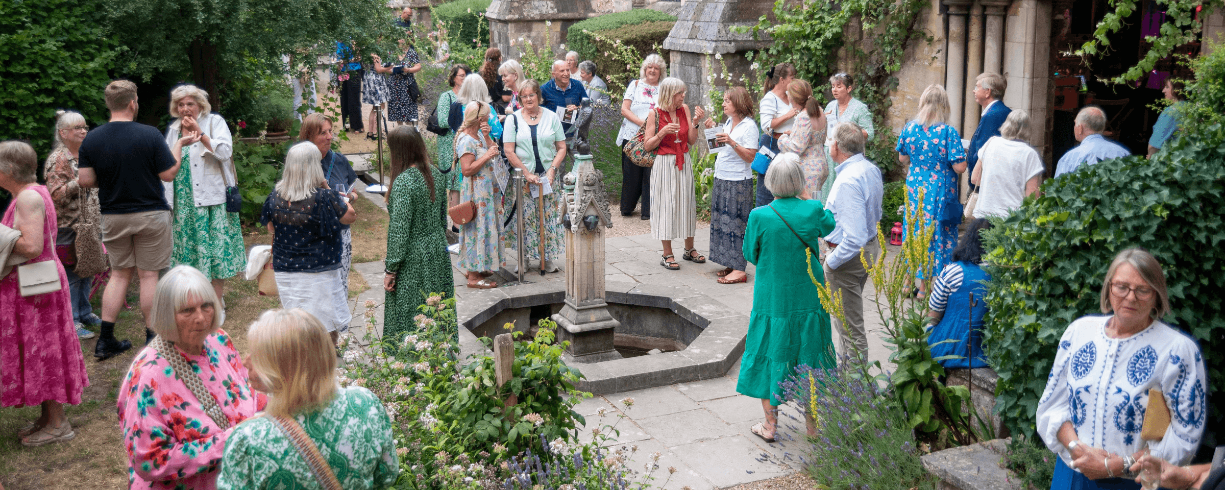 A large group of people chatting in a courtyard at a Legacy Summer of Music event.