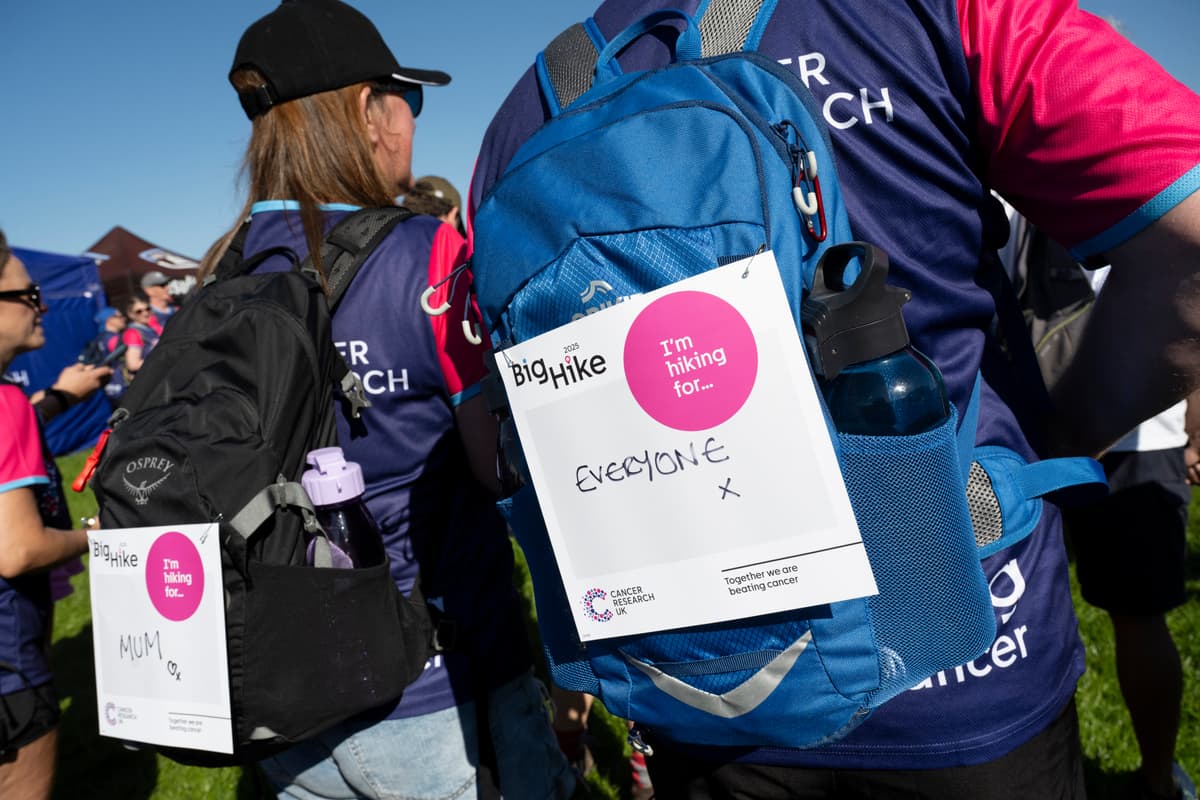Cancer Research UK back signs on the backpacks of hikers.