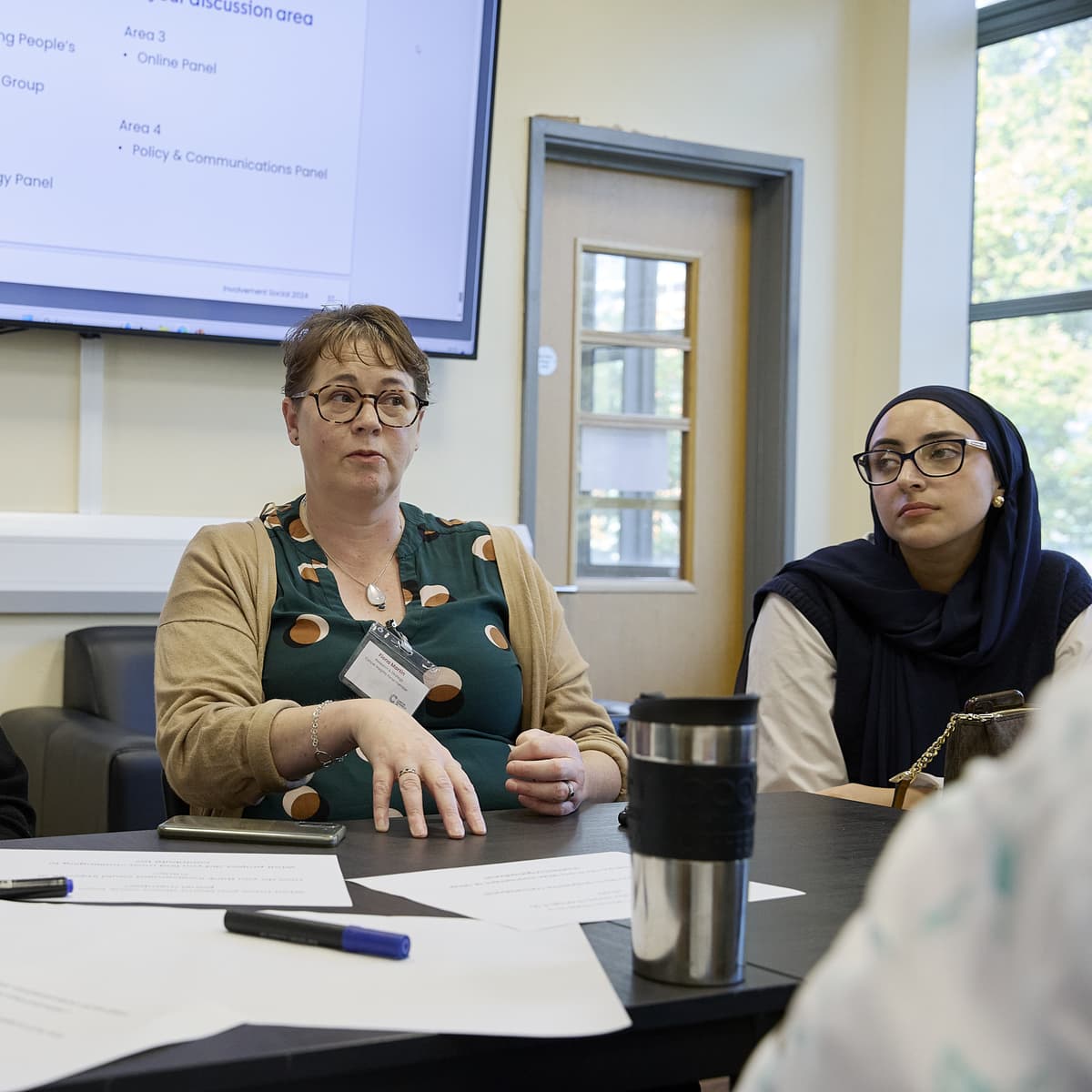 A group of people sat around a table in discussion.
