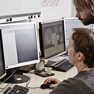 Photo of 2 people looking at a computer