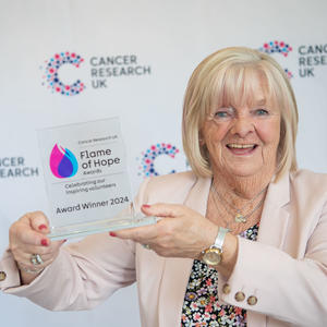 Marie holding her Flame of Hope trophy