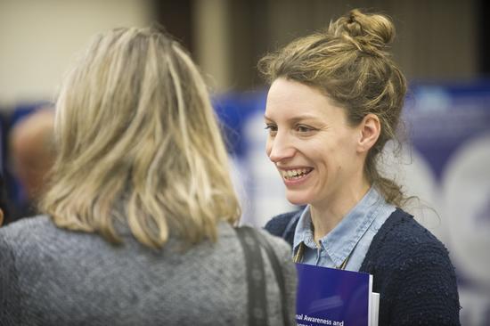 two people in discussion at a conference