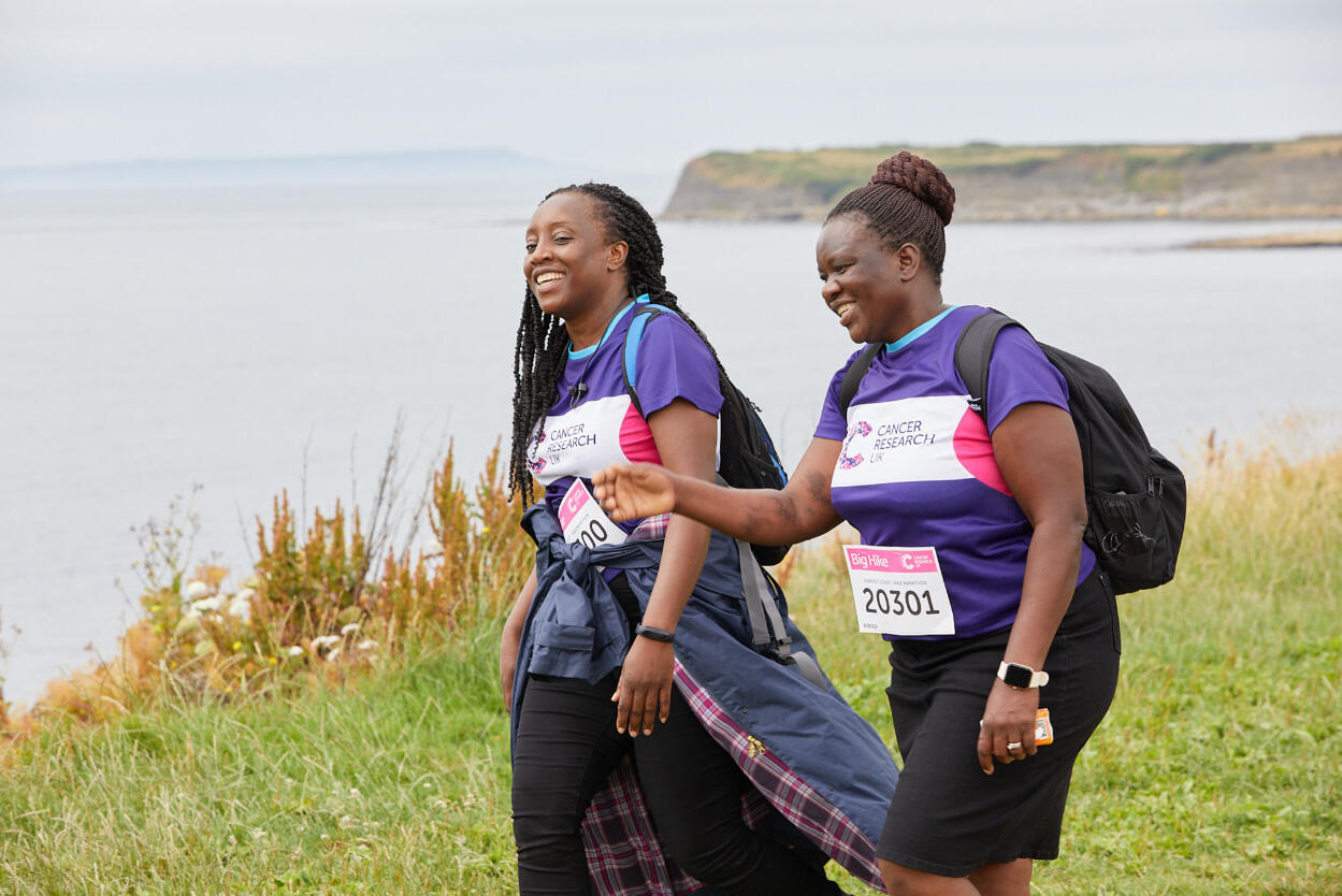 2 ladies laughing walking along the coast line of Jurassic Coast