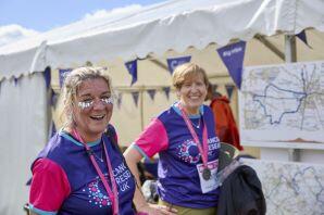 2 ladies with glitter on their faces smiling after completing a Big Hike event