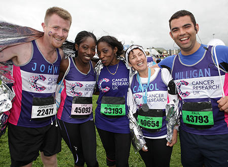 A group photo of five Cancer Research UK runners at the end of their race