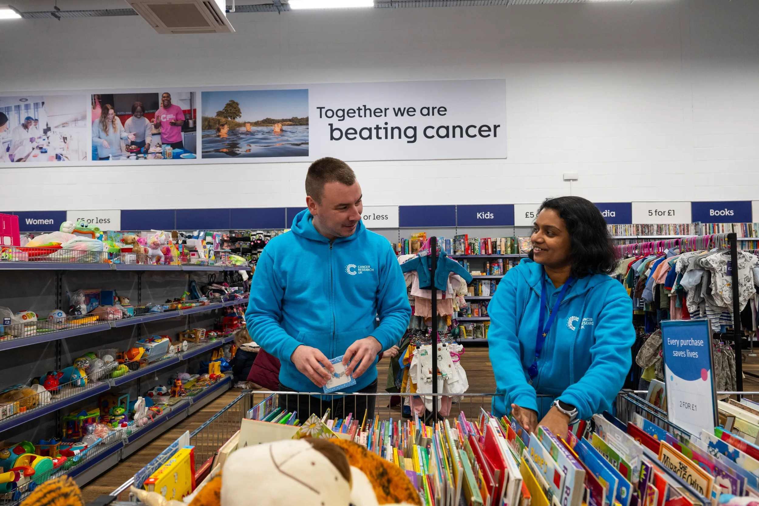 Two shop volunteers working together and smiling