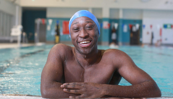 Male swimmer smiling by side of pool at swimathon 