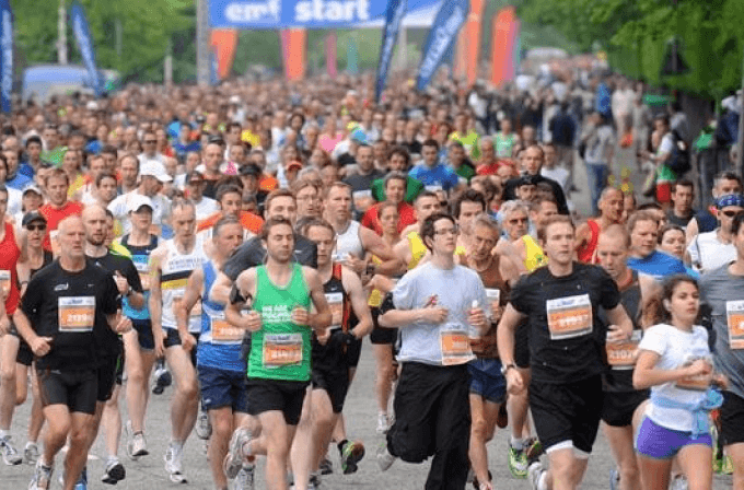 Group of runners in different coloured t-shirts running a marathon