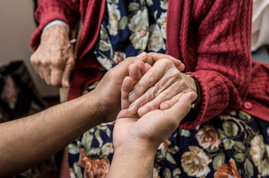 Photo of nurse holding patient hand
