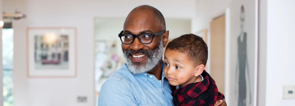 a man holding a child, both are smiling