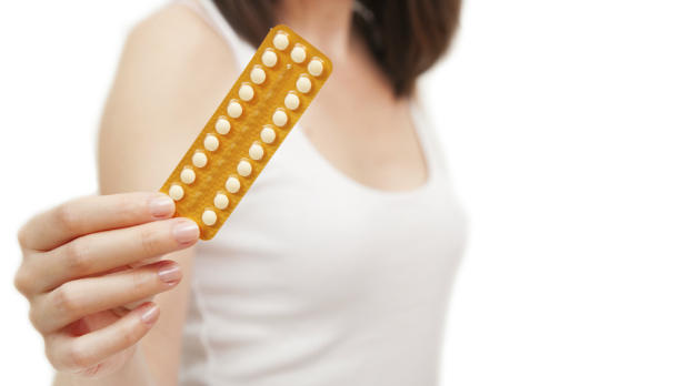 Woman holding contraceptive pills