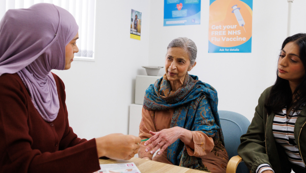 Doctor at the GP surgery talking to the patient and her carer