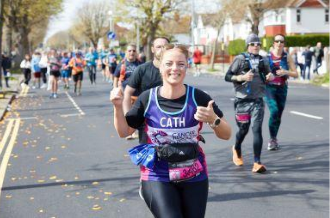 Woman smiles as she runs the race for CRUK