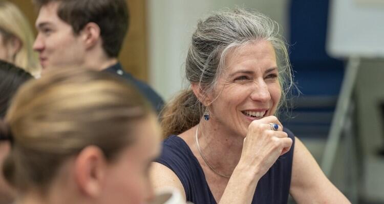 Smiling woman sat at a table with others