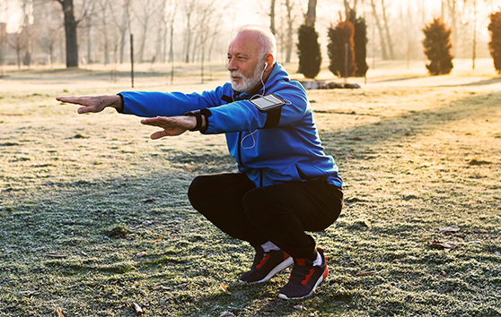 Man squatting in park
