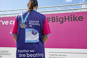 back of a woman showing her Big Hike back sign and medal