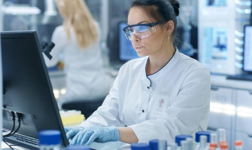 Female scientist seated at a computer in the lab