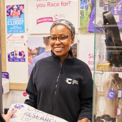 volunteer behind till at CRUK store