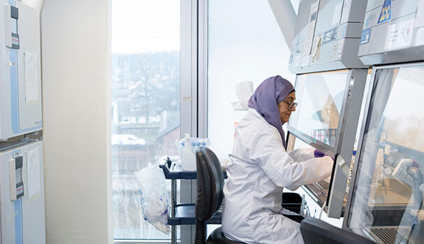 A researcher working by a fume hood in a lab