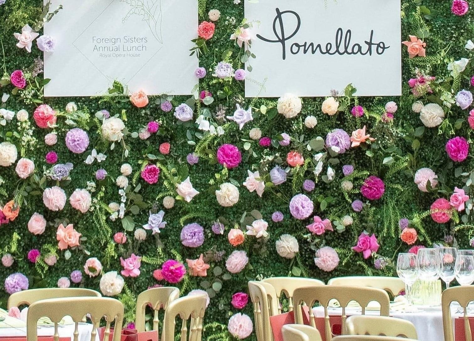 Wall of flowers with the Pomellato sign on it