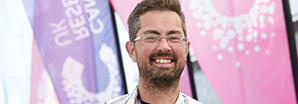 Man in front of Cancer Research UK flags after a swim