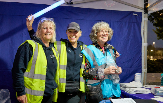 Three event volunteers smiling
