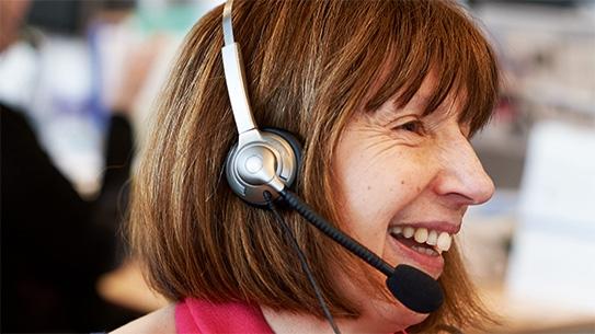 A cancer nurse talking on the phone, wearing a headset