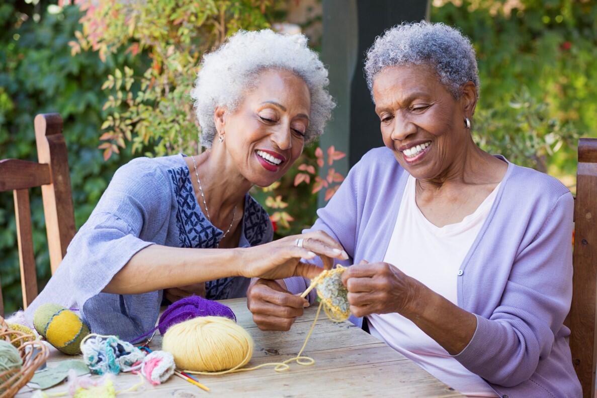 Two women knitting and smiling